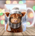 A white ceramic mug featuring a printed image of a fluffy brown highland cow wearing a white plaid beanie and matching scarf, set against a blurred festive bokeh background with a wooden surface.