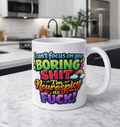 A white ceramic coffee mug with a colorful, bold graphic text design reading 'I can't focus on your BORING SHIT I'm Neurospicy as FUCK!' sits on a white marble countertop with a blurred modern kitchen in the background.