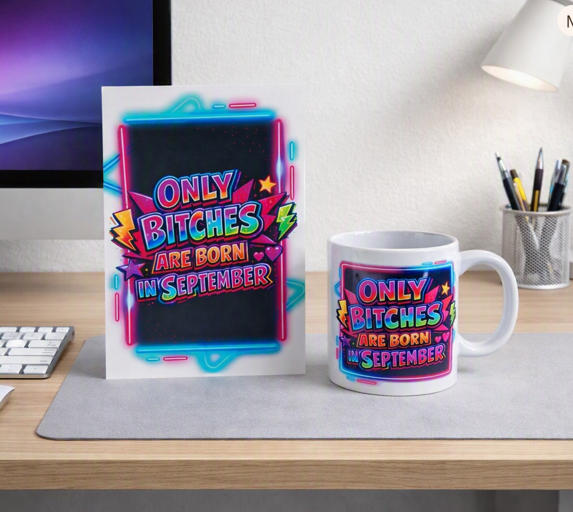 A white ceramic mug and a matching printed card stand on a desk, both featuring a colorful neon-style graphic that reads “ONLY BITCHES ARE BORN IN SEPTEMBER” over a dark background.