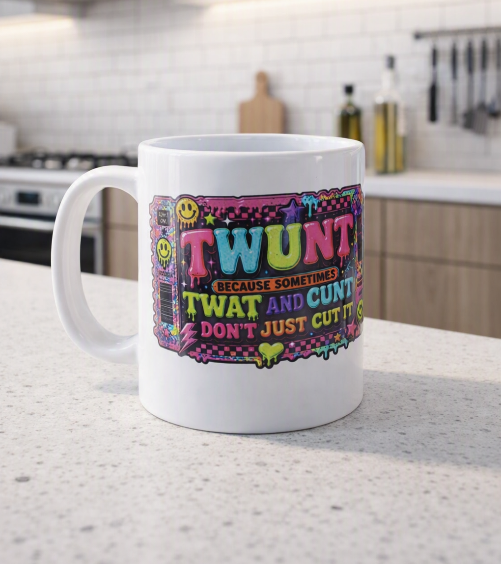 A white ceramic mug with a colorful retro graphic design featuring the word 'TWUNT' and a humorous quote, set on a kitchen countertop with a blurred kitchen background.